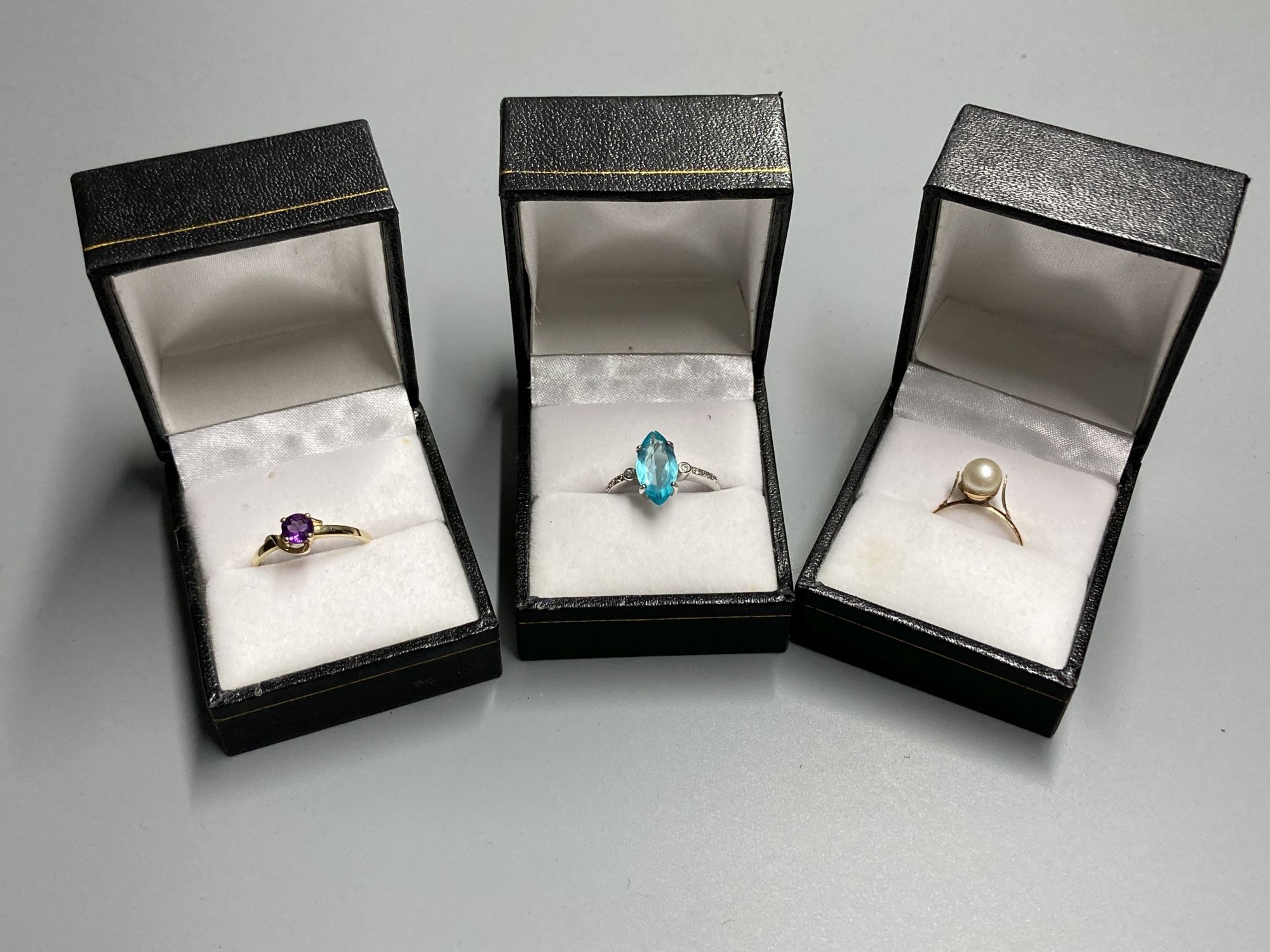 Three assorted modern 9ct and gem set dress rings, including white gold and marquise shaped blue topaz ring, size N/O,